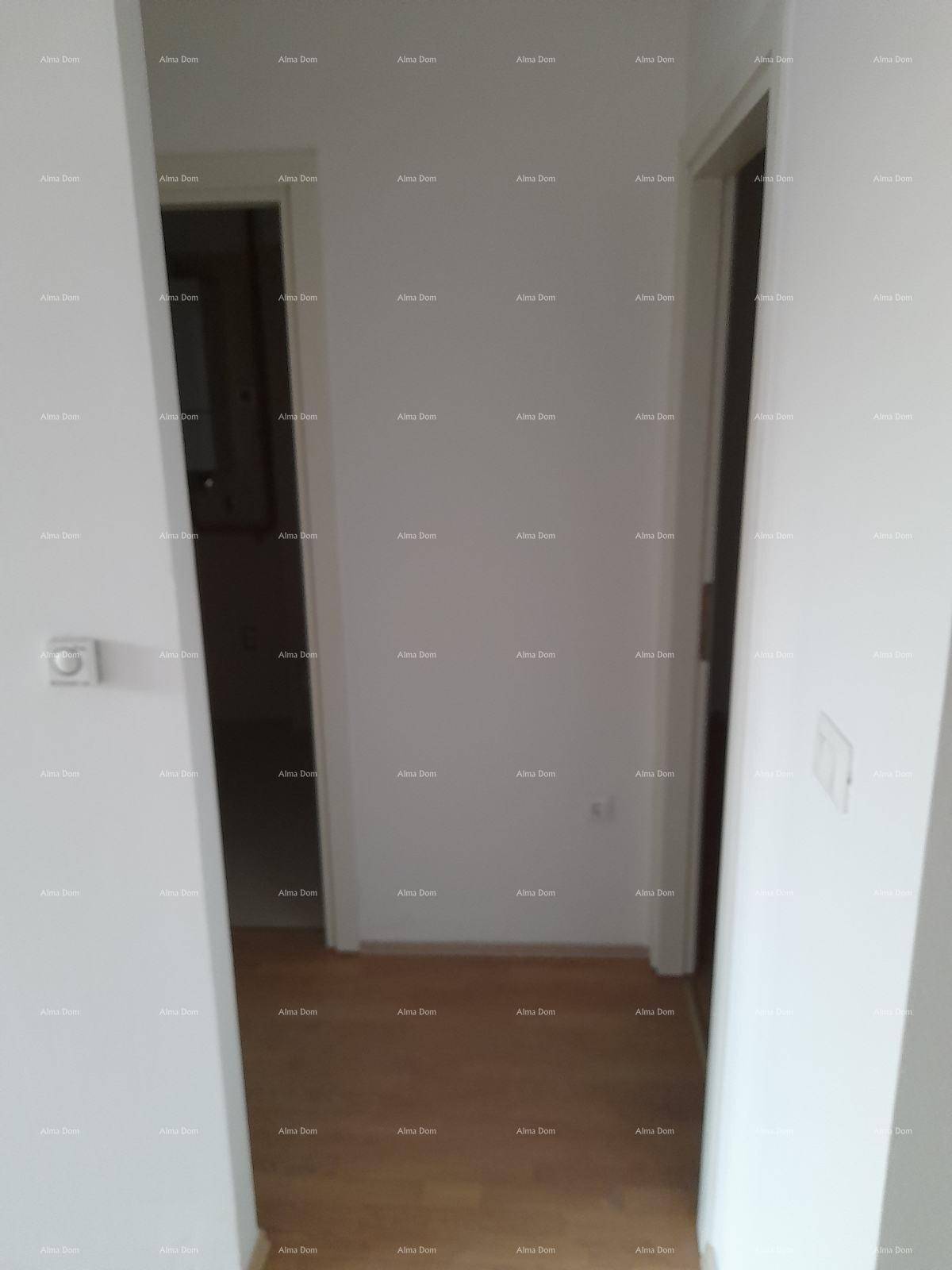 Schmaler Flur mit hellen Wänden und Holzboden, der zu weiteren Räumen führt.