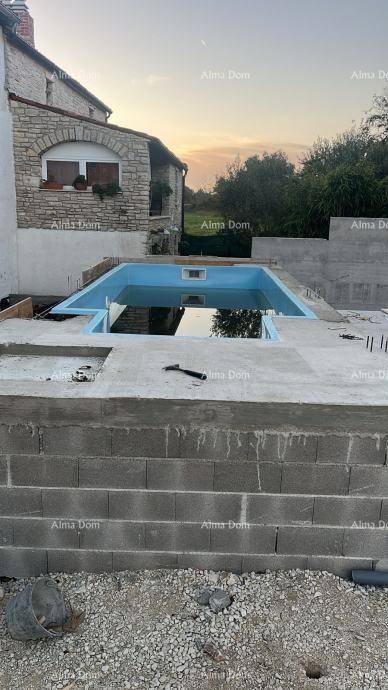 Im Bau befindlicher Pool mit blauer Auskleidung und umgebenden Betonstrukturen bei Sonnenuntergang.
