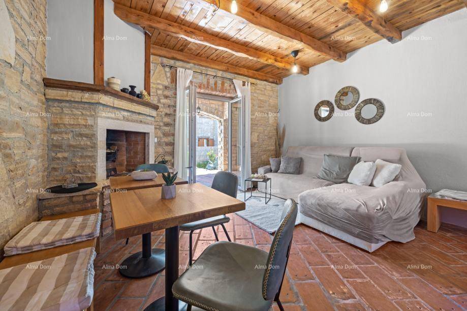 Rustikales Wohnzimmer mit Steinwand, Holzbalkendecke und traditionellem Kamin.