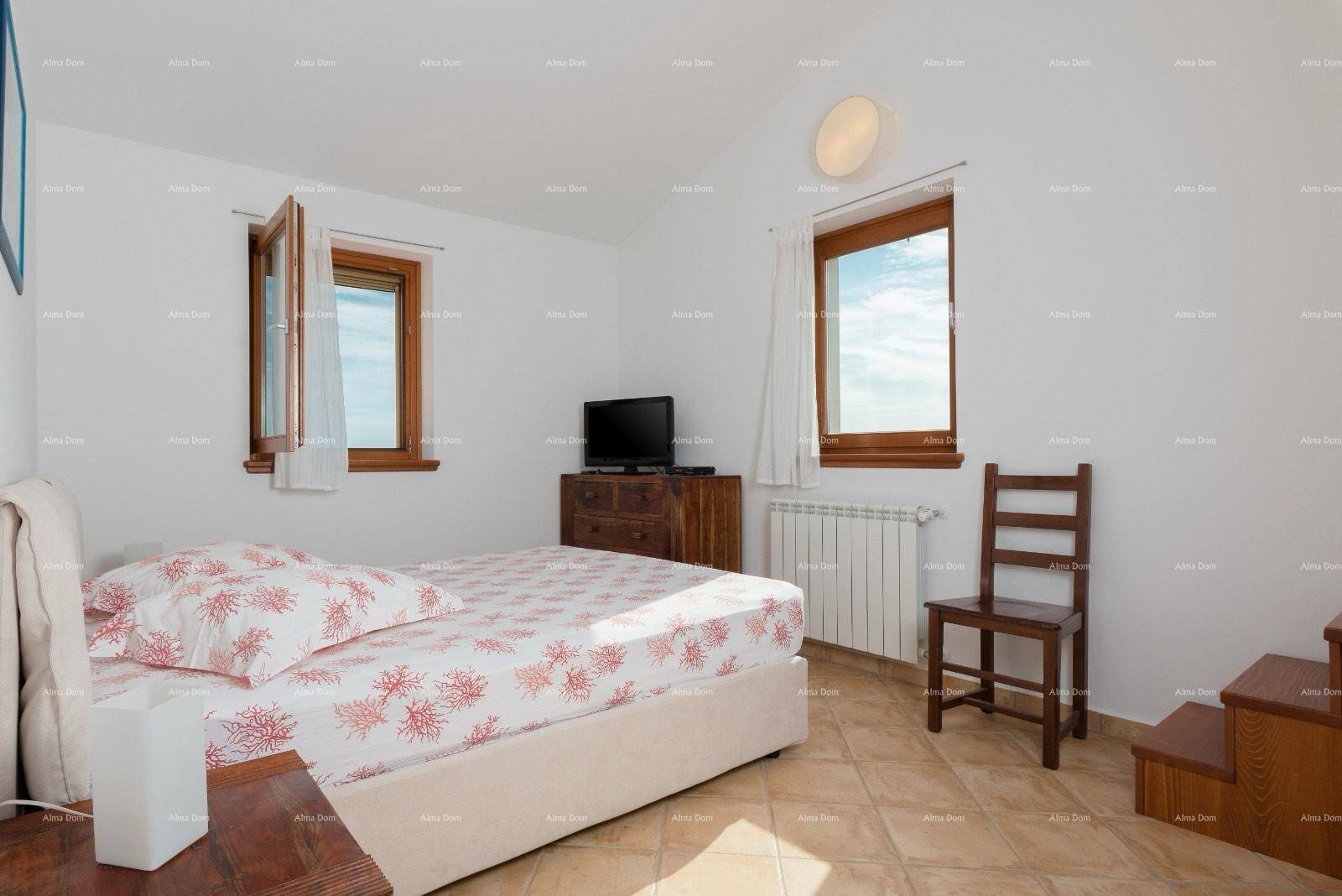 Komfortables Schlafzimmer mit Einzelbett, Fernseher auf einer Kommode und zwei Fenstern für viel Tageslicht.