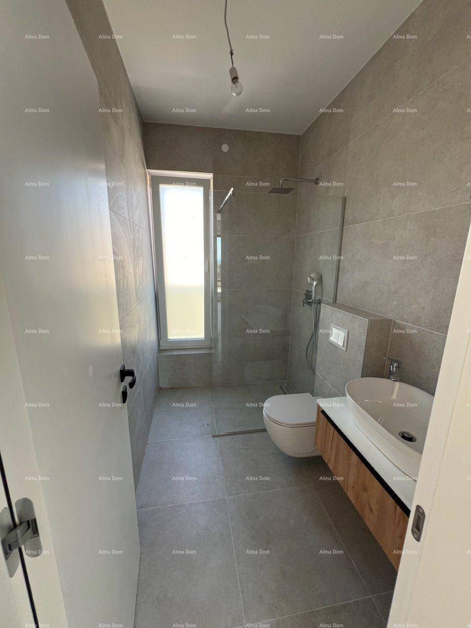 Modernes Badezimmer mit grauen Fliesen, bodengleicher Dusche und schwebendem Waschtisch.