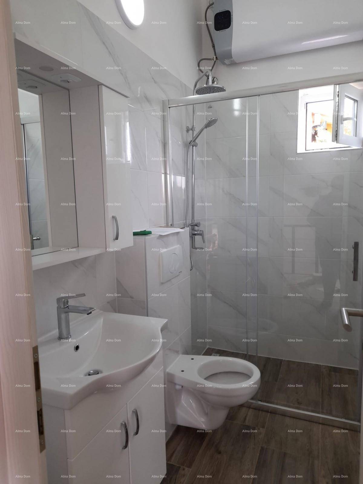 Modernes Badezimmer mit Duschkabine, wandhängendem WC und Waschbecken mit Unterschrank.