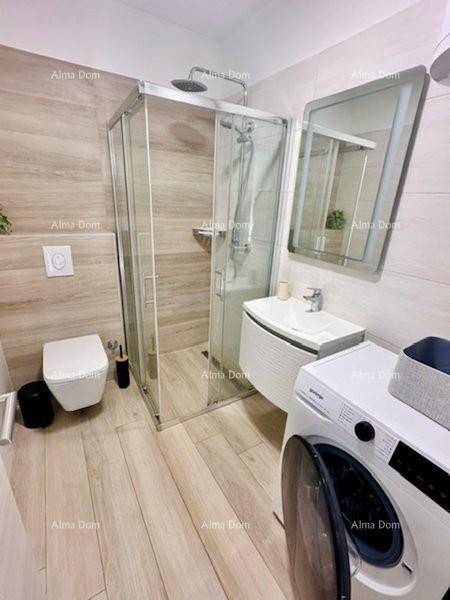 Modernes Badezimmer mit Duschkabine, wandhängendem WC und Waschmaschine.