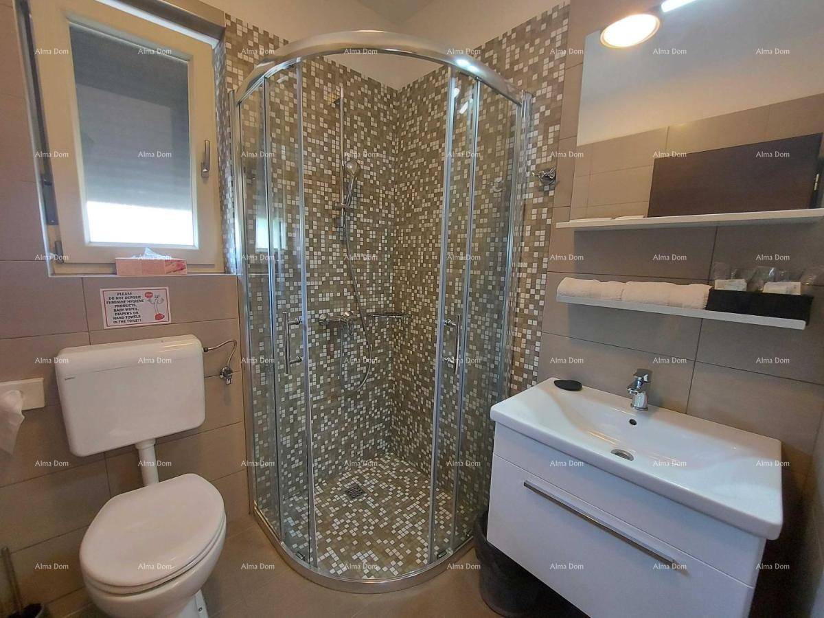 Kompaktes Badezimmer mit Eckduschkabine, Toilette und Waschtisch, praktisch und hell gefliest.