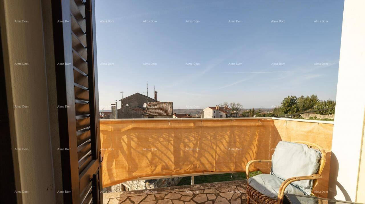 Kleiner Balkon mit Korbstuhl und Blick auf die umliegende Nachbarschaft.