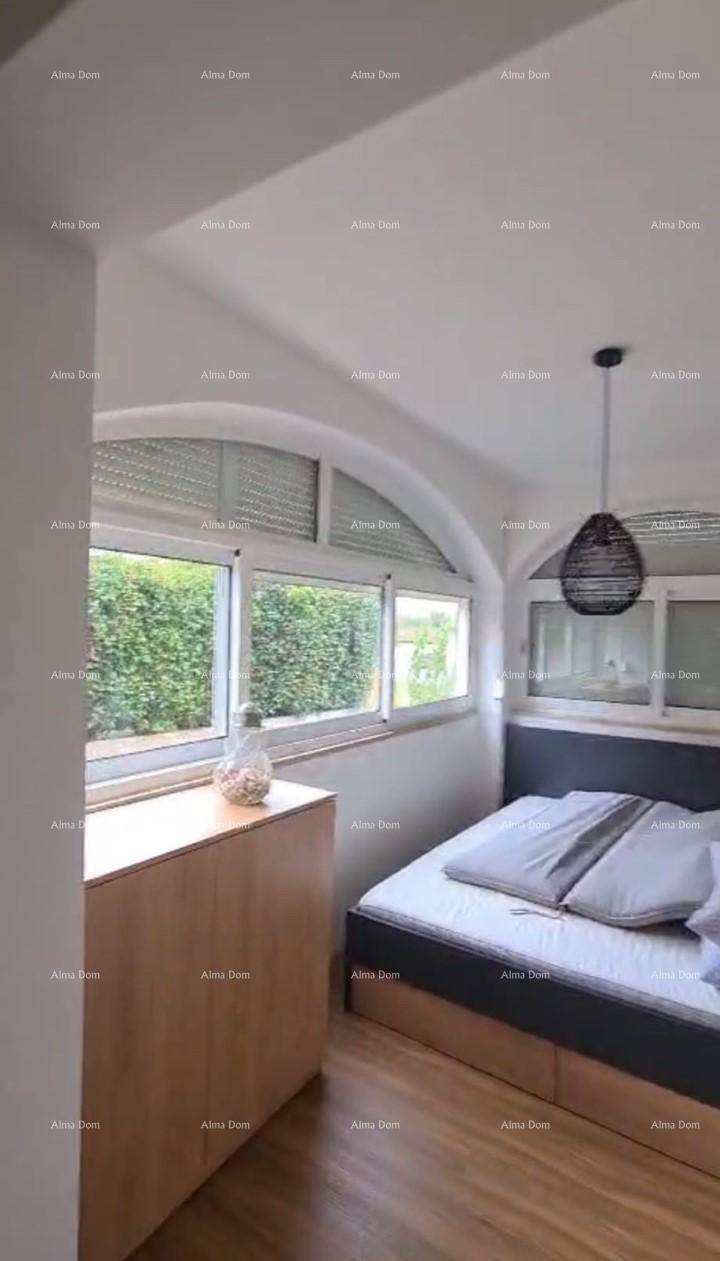 Schlafzimmer mit Dachschräge, großen Fenstern und einem modernen Hängelicht.