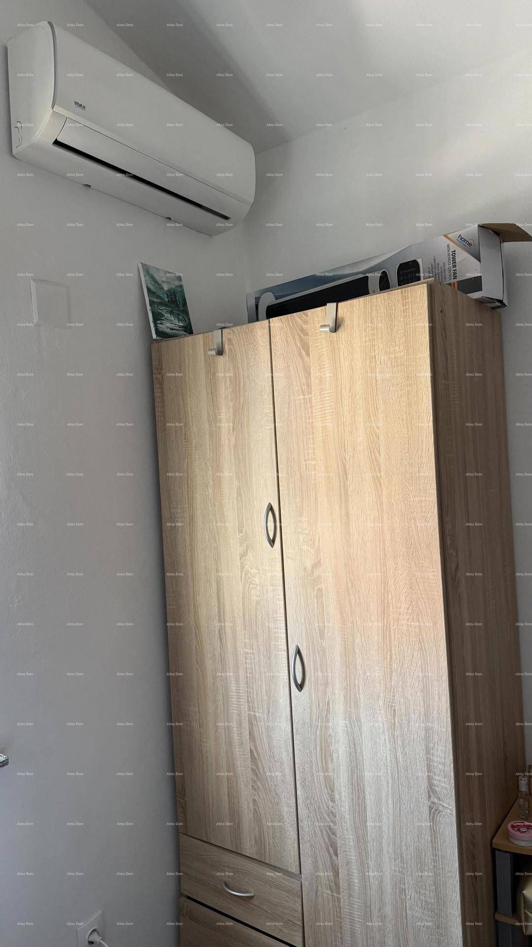 Klimaanlage über einem hellen Holzschrank in einem Schlafzimmer installiert.
