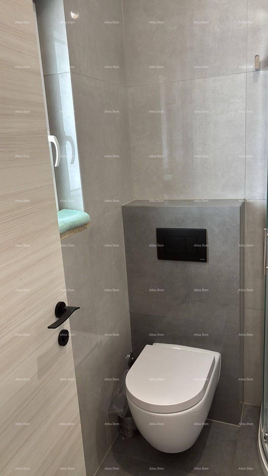Modernes wandhängendes WC in einem gefliesten Badezimmer mit einem Fenster für natürliches Licht.