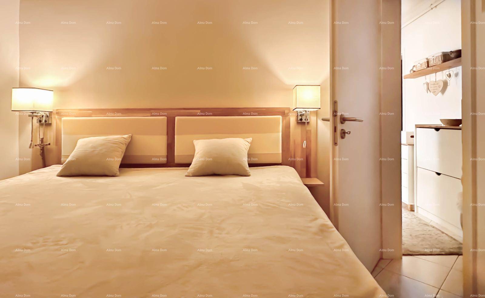 Schlafzimmer mit Doppelbett, Nachttischlampen und Zugang zu einem anderen Raum.