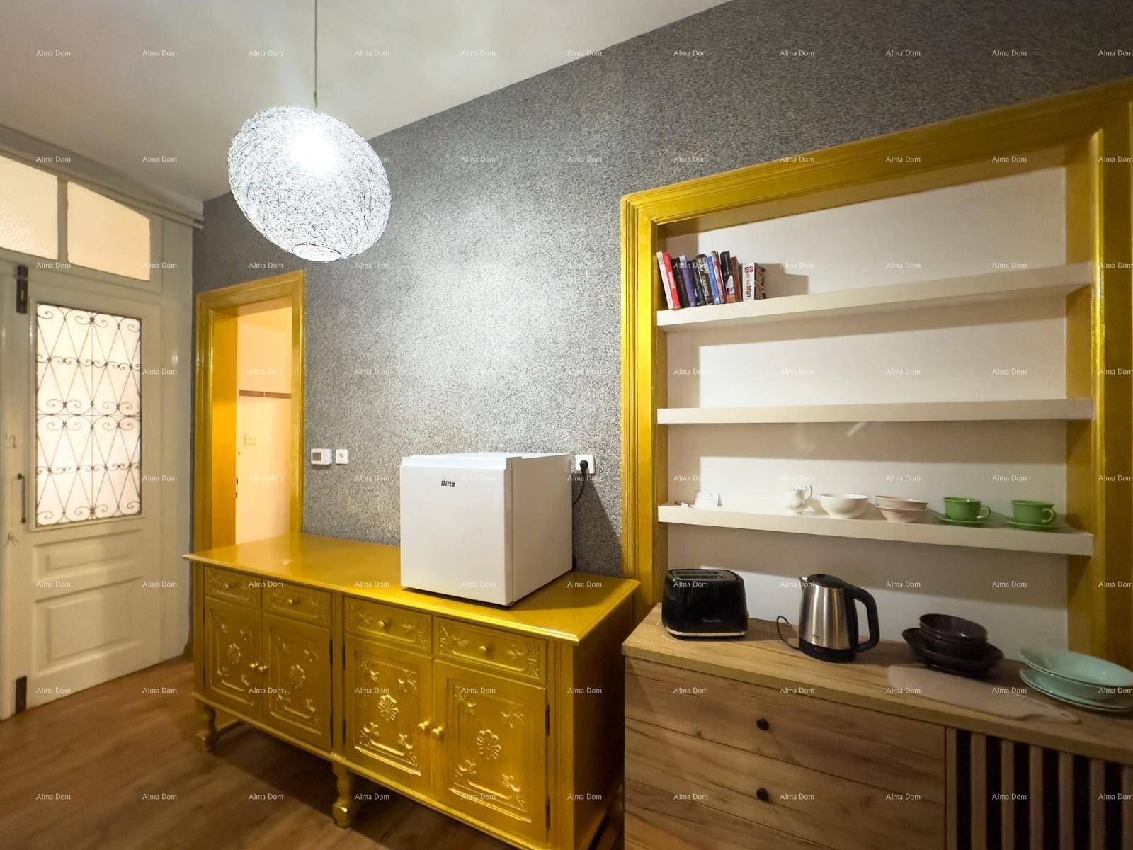 Eingangsbereich mit weißer Tür, goldenem Schrank, kleinem Kühlschrank und Regalen mit Geschirr.