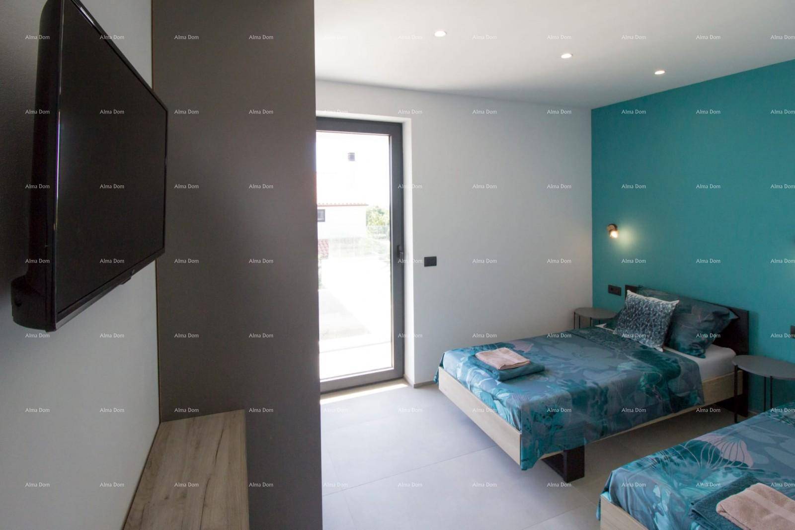 Schlafzimmer mit zwei Einzelbetten, Fernseher und einer lebhaften blauen Akzentwand.