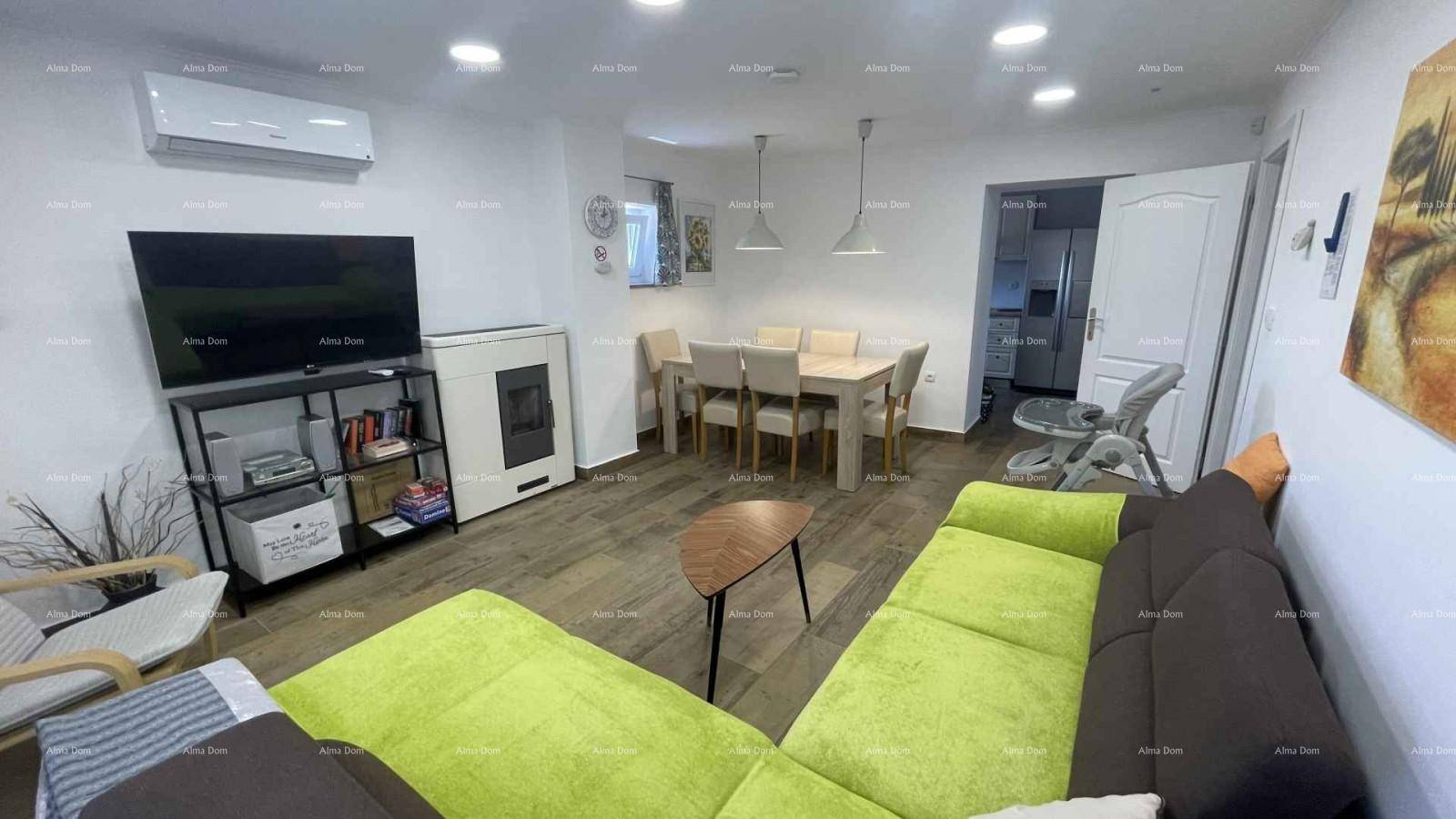 Geräumiger Wohn- und Essbereich mit bequemer Couch, Fernseher und Klimaanlage.
