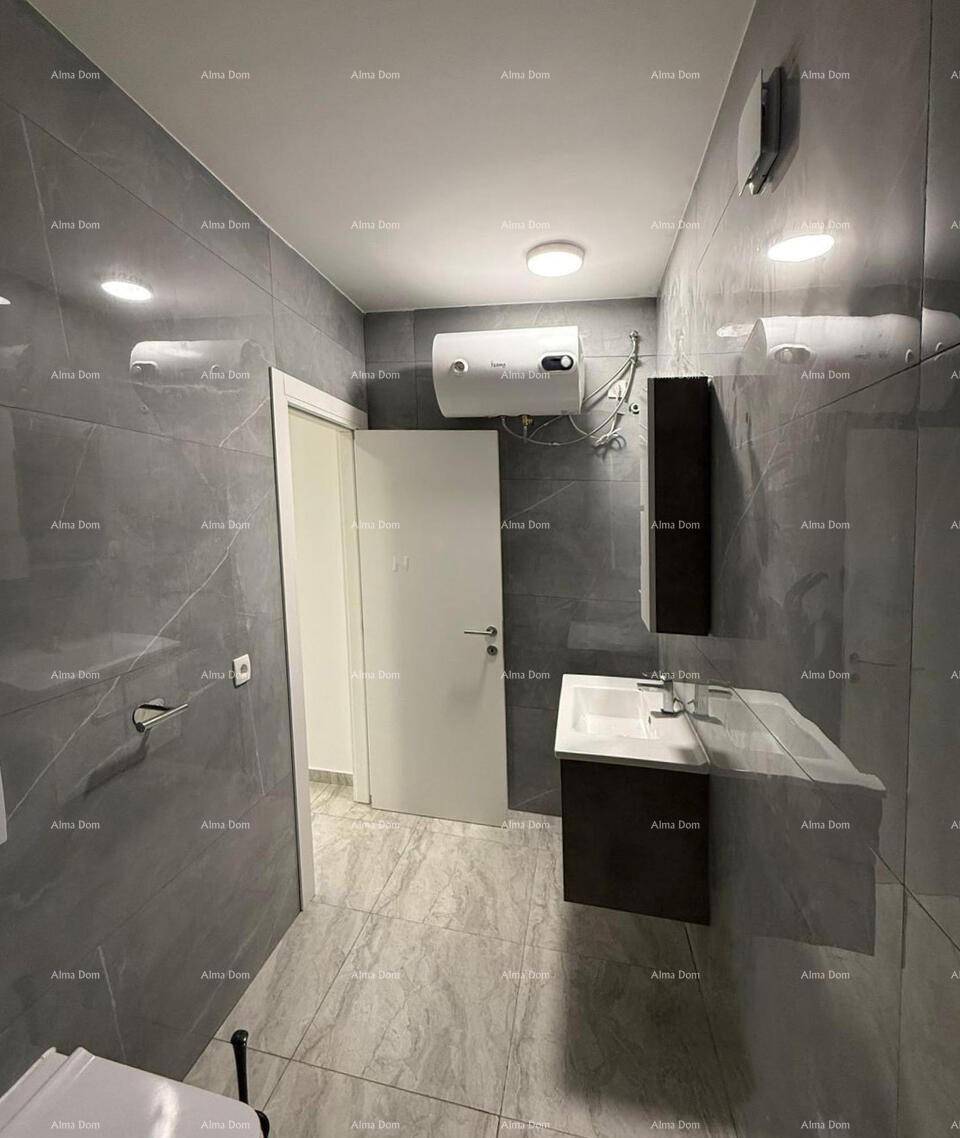 Badezimmer mit modernem Waschtisch, Wandspiegel und einem Warmwasserboiler an der Wand.