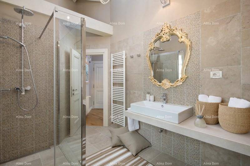Elegantes Badezimmer mit begehbarer Dusche, Einzelwaschbecken und goldenem Spiegel.