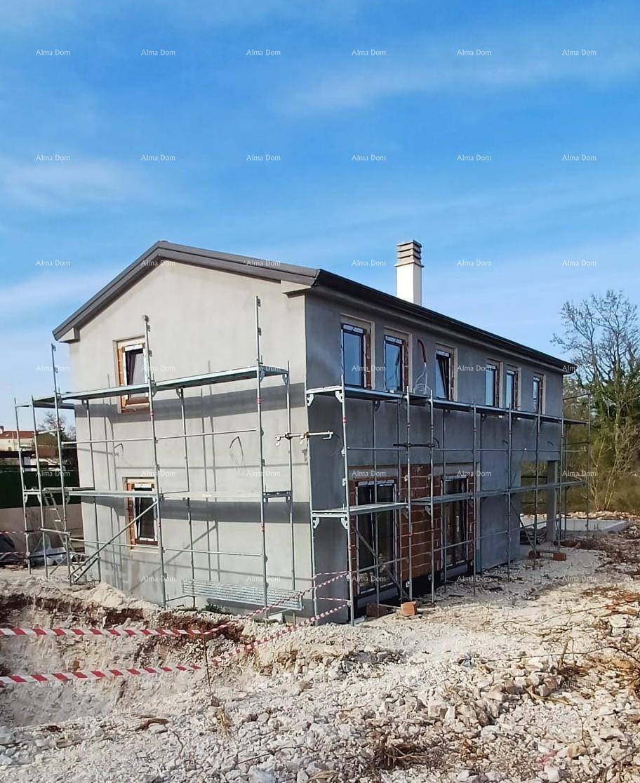 Seitenansicht eines im Bau befindlichen Hauses mit Gerüst und Fenstern.