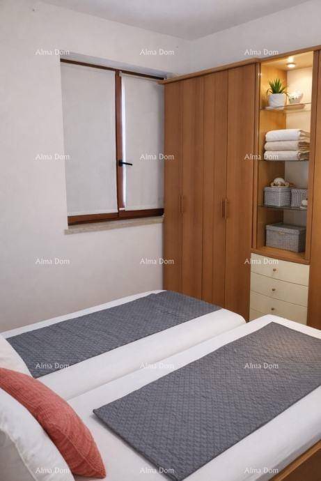 Helles Schlafzimmer mit zwei Einzelbetten und einem praktischen Einbauschrank aus Holz.