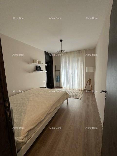Helles Schlafzimmer mit Holzboden, großem Fenster und minimalistischer Einrichtung.