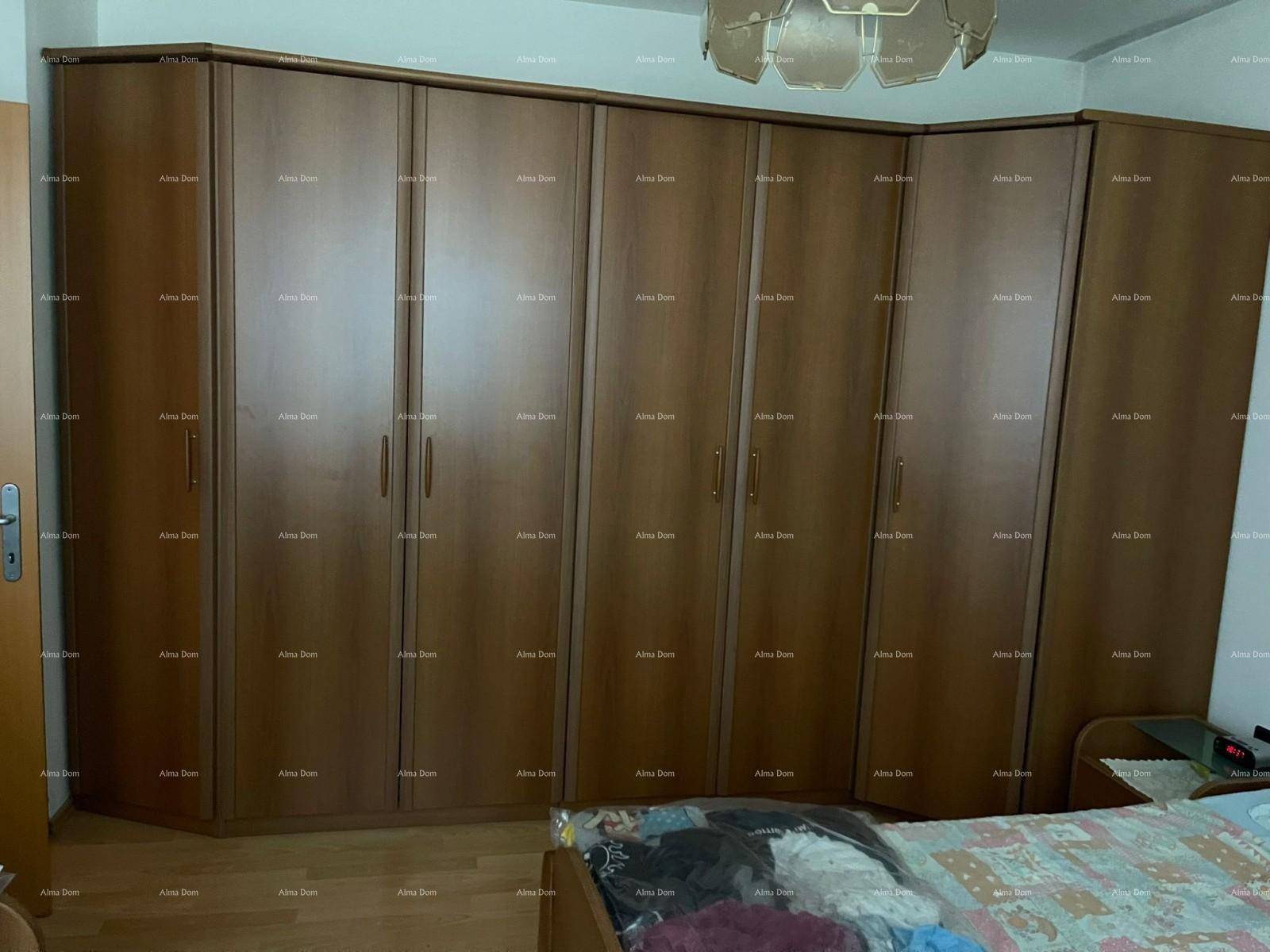 Schlafzimmer mit einem großen Eckkleiderschrank aus Holz und einem bequemen Doppelbett.