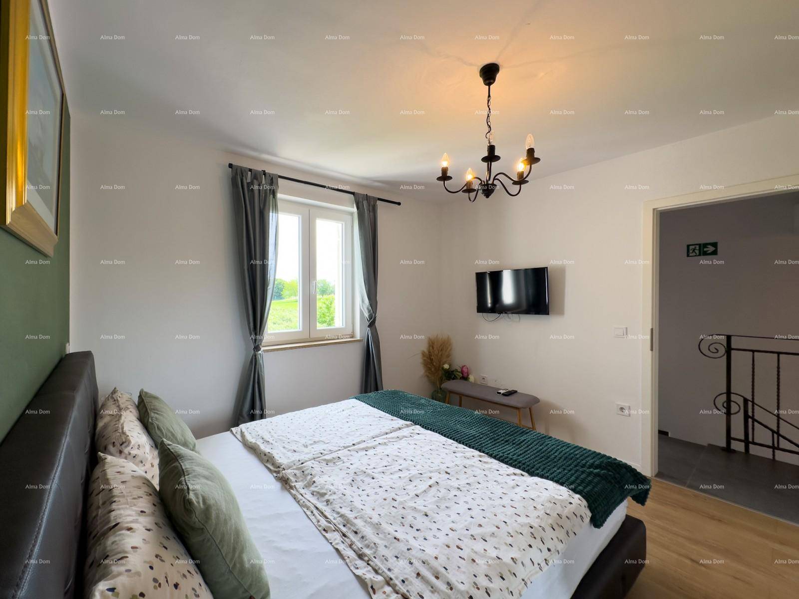 Helles Schlafzimmer mit Doppelbett, Fernseher und Blick ins Grüne durch das Fenster.