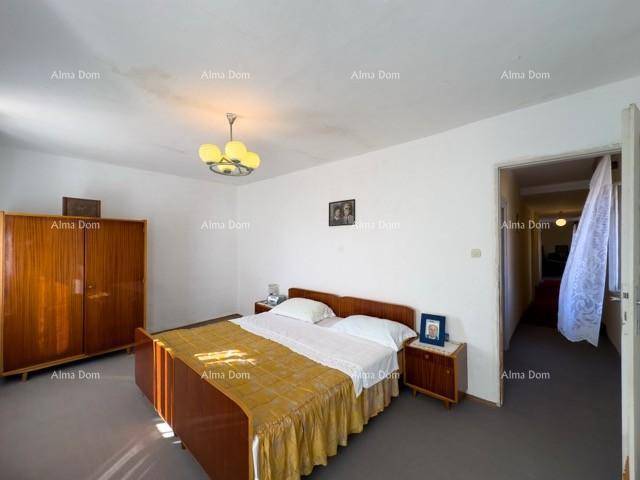 Schlafzimmer mit einfacher Einrichtung, Doppelbett und einem Kleiderschrank aus Holz.