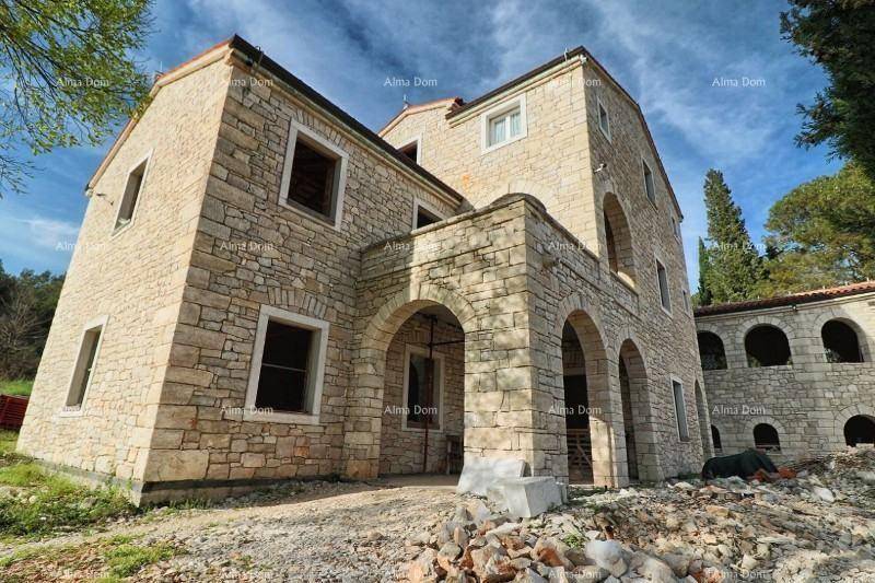 Weitläufiges Steinhaus im Rohbau mit mehreren Ebenen und traditionellen Architekturelementen.