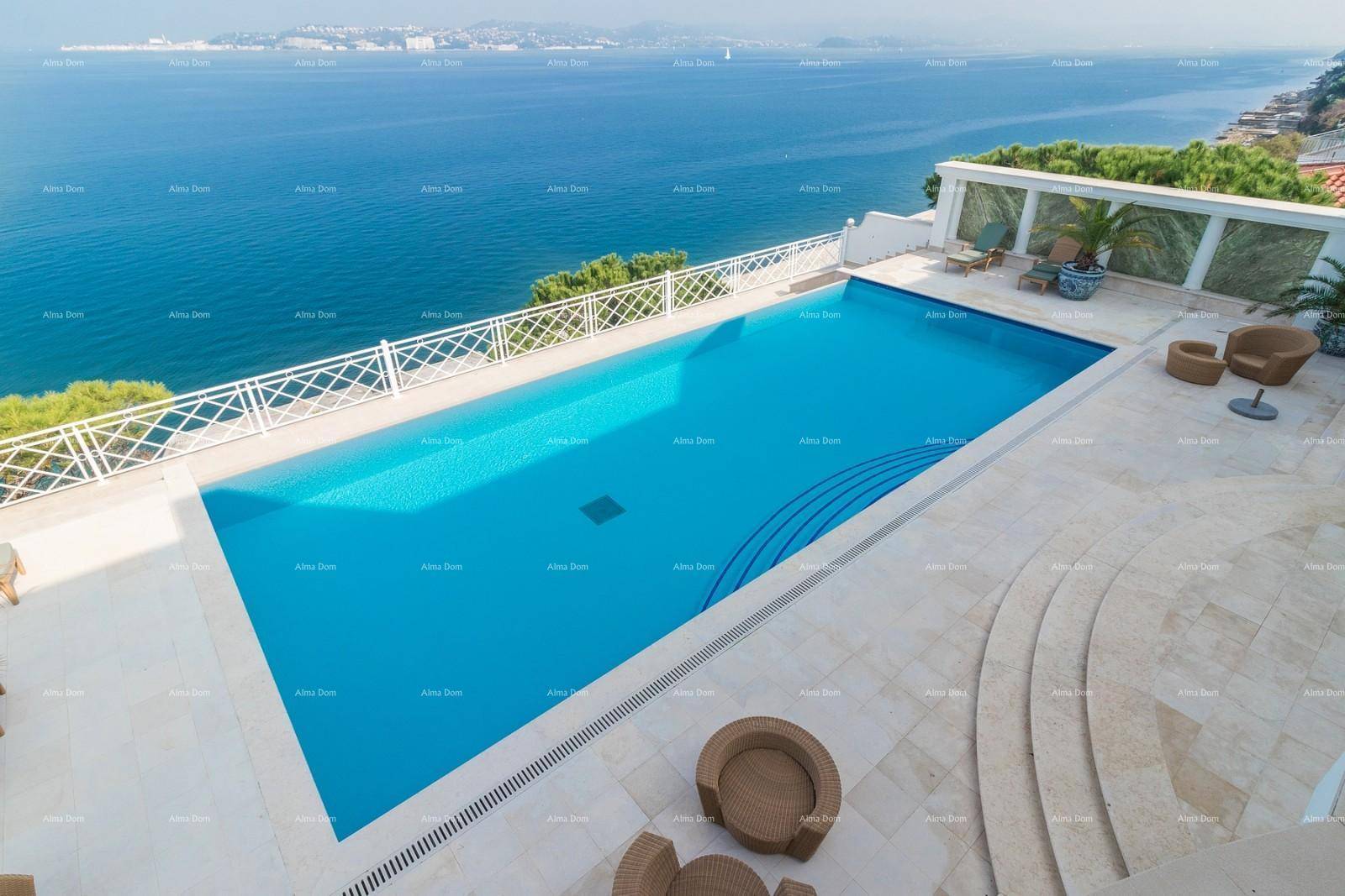 Weitläufiger Poolbereich mit Meerblick, umgeben von hellen Fliesen und bequemen Sitzgelegenheiten.
