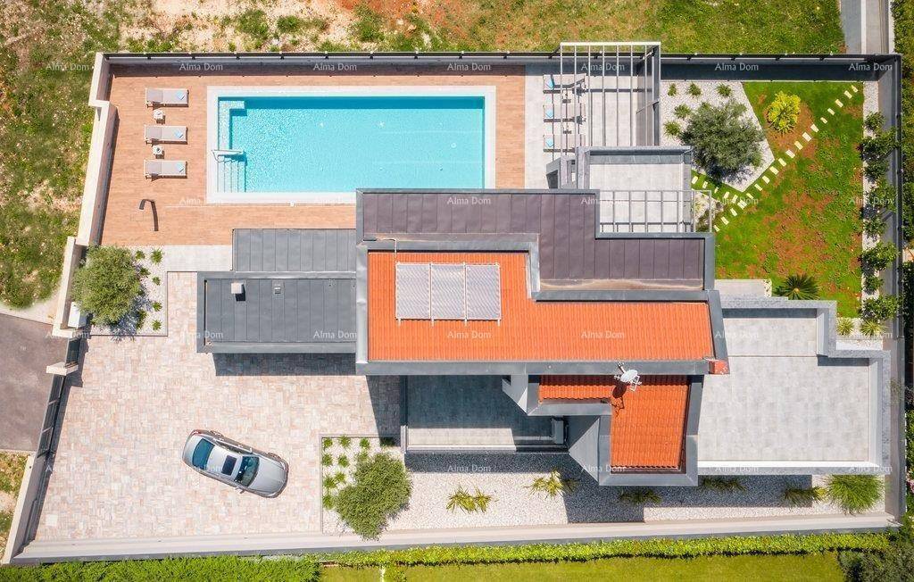 Luftaufnahme der modernen Villa mit großem Pool, Gartenanlage und Parkplatz.