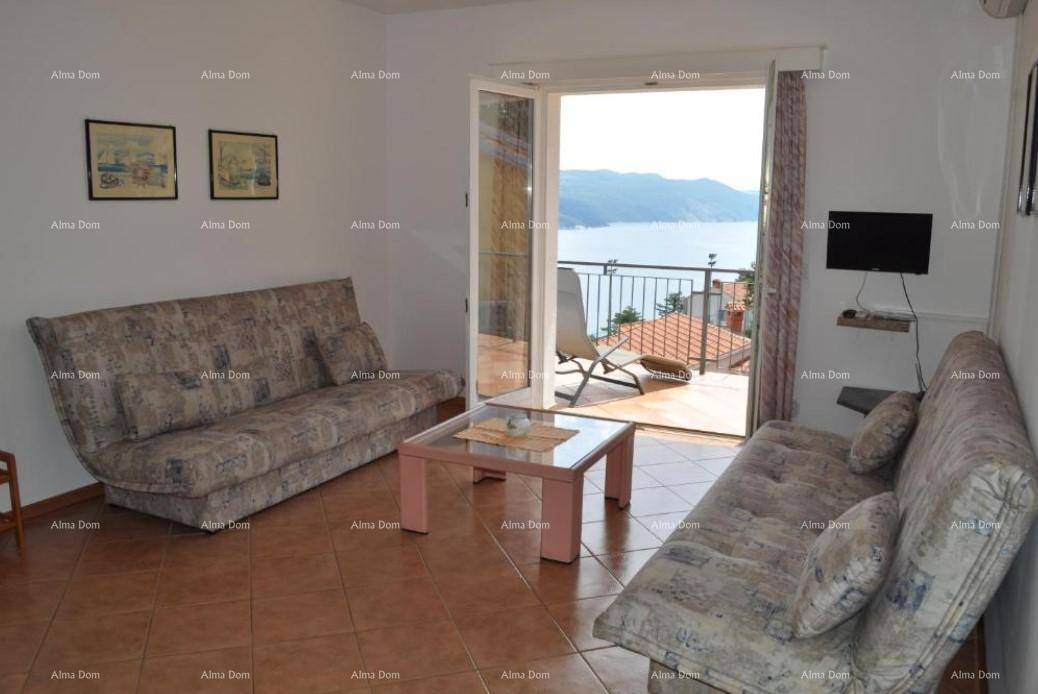 Wohnzimmer mit zwei Sofas, Couchtisch und Zugang zu einem Balkon mit Meerblick.