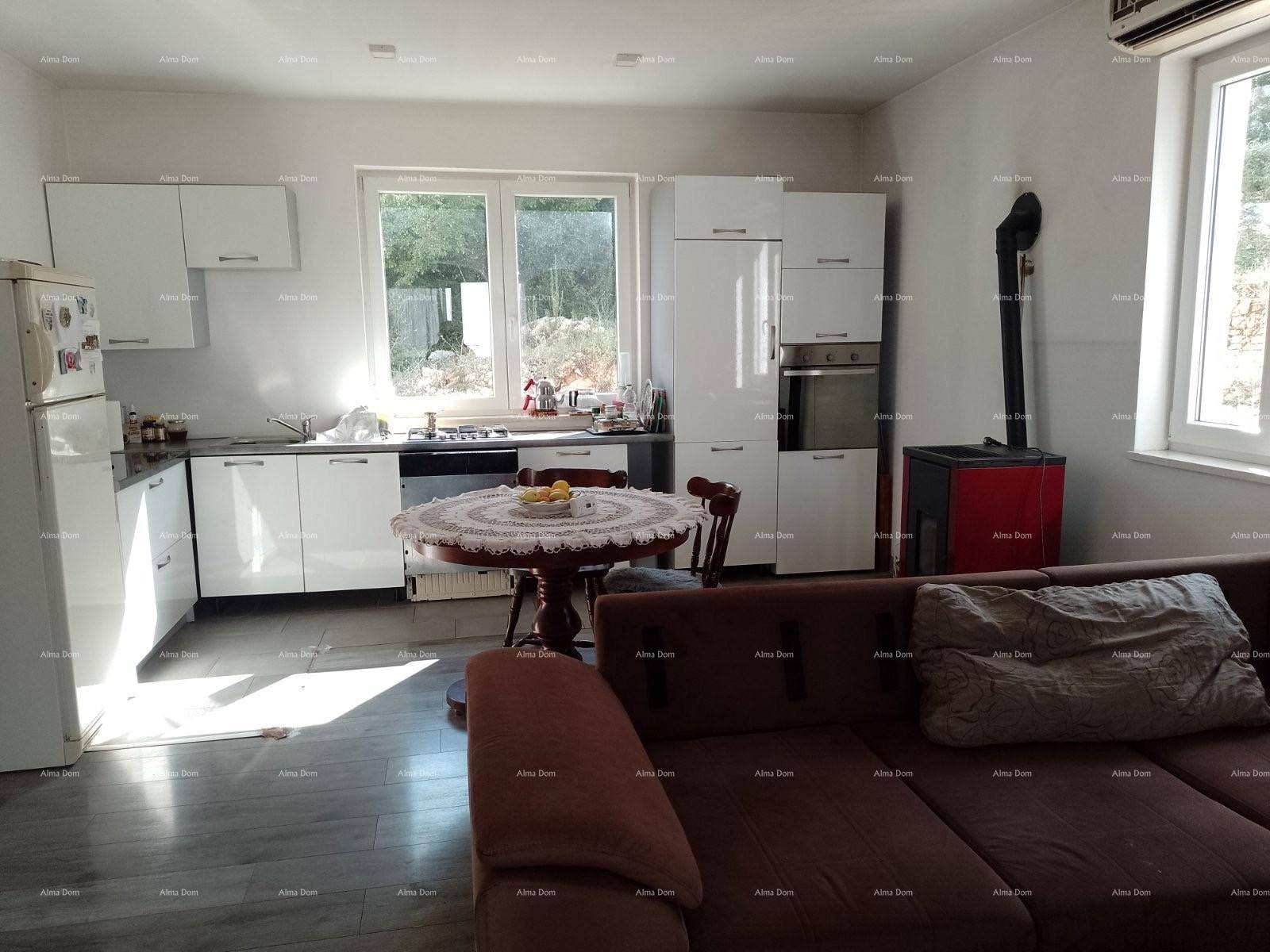 Geräumiger Wohn- und Essbereich mit offener Küche, Holzboden und einem gemütlichen Sofa.