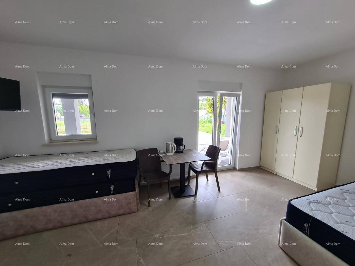Helles Schlafzimmer mit zwei Betten, kleinem Tisch und direktem Zugang zum Garten.