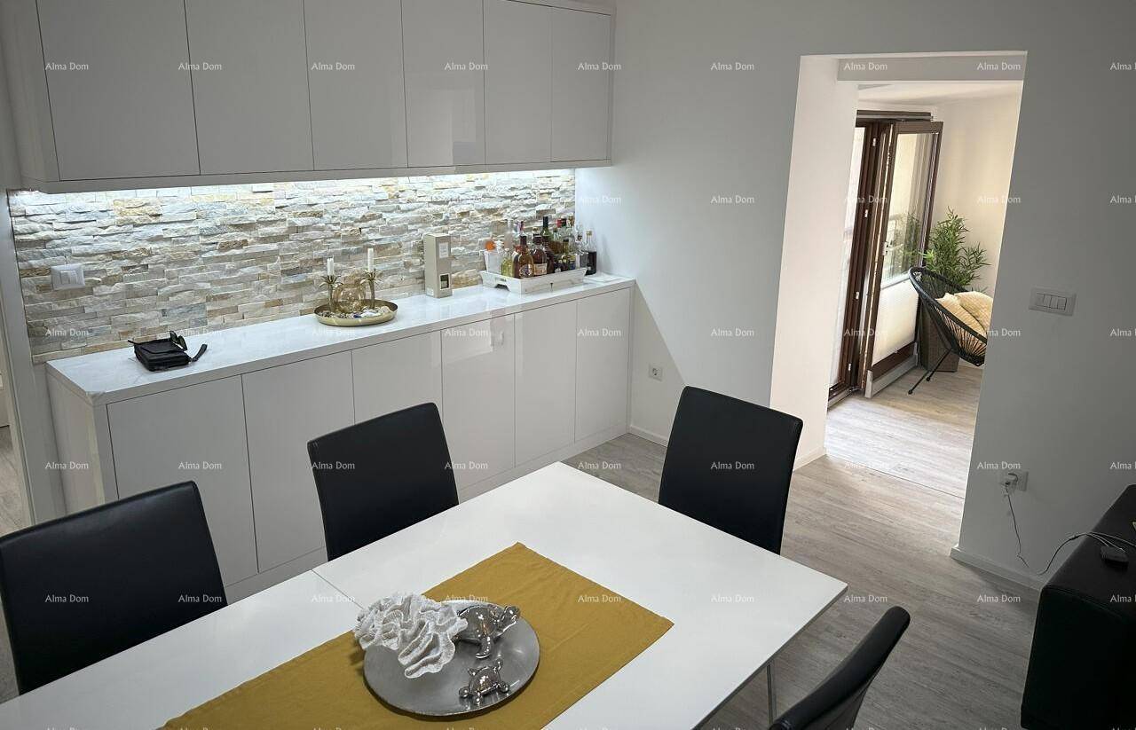 Moderner Essbereich mit weißem Tisch, schwarzen Stühlen und einer dekorativen Steinwand.