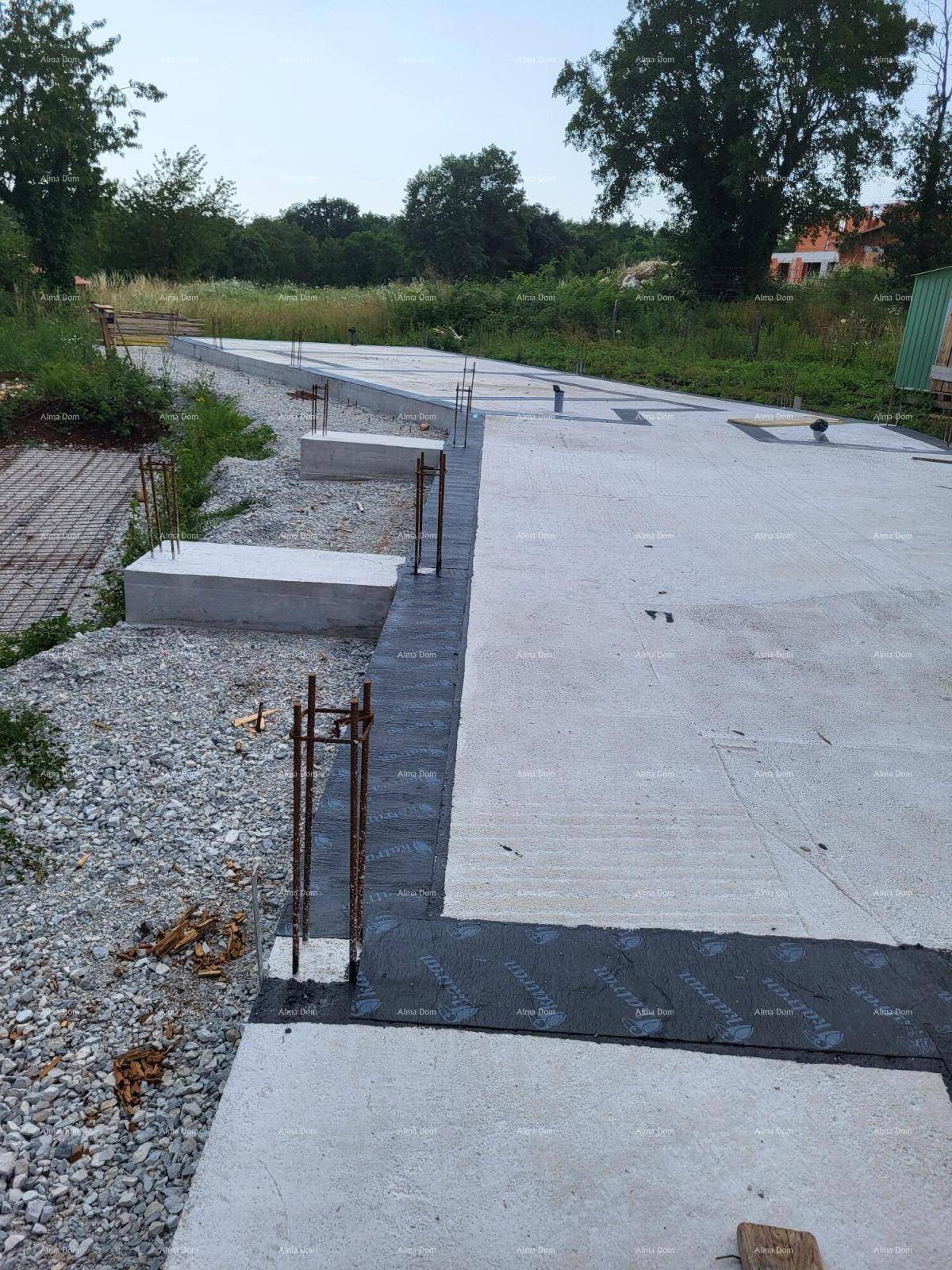 Langes Betonfundament mit Bitumenabdichtung und Bewehrungseisen, bereit für den weiteren Baufortschritt.