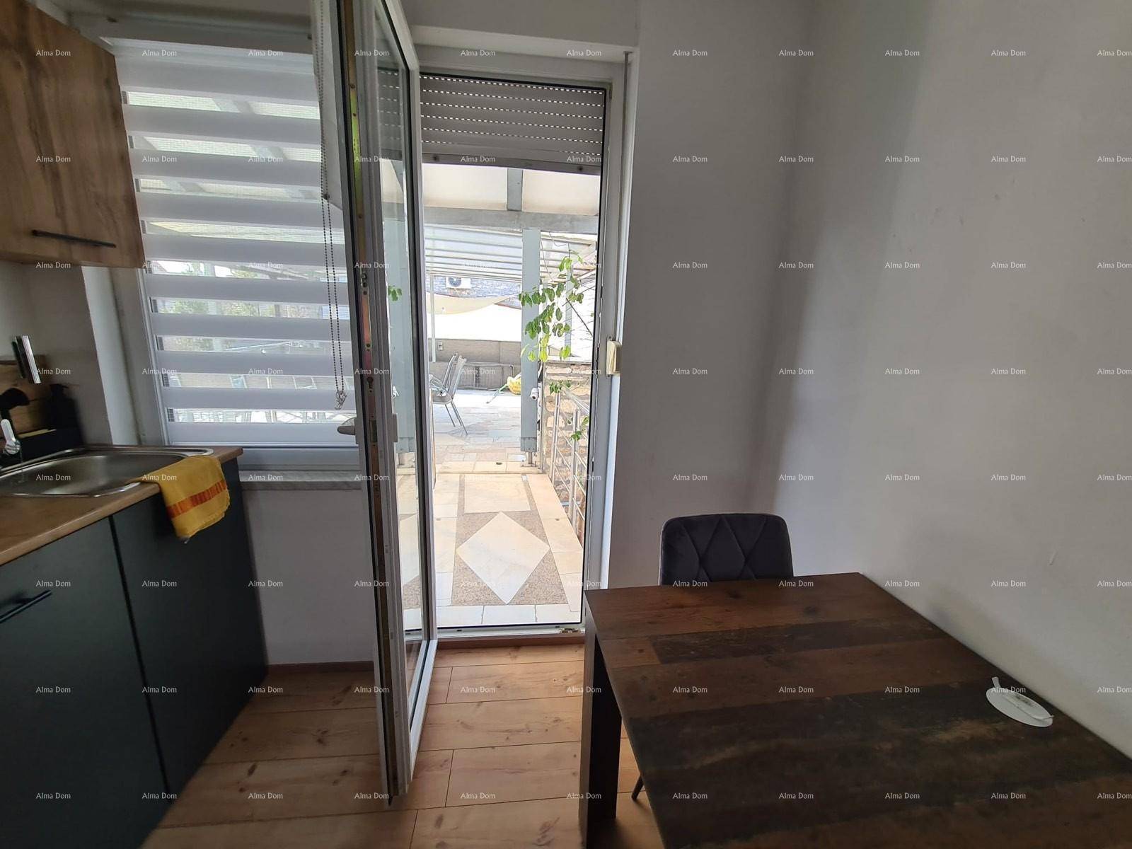 Küchenzeile mit Esstisch und Blick auf die überdachte Terrasse durch die geöffnete Tür.