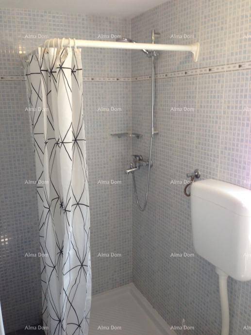 Badezimmer mit Duschkabine, WC und hellen Fliesen.