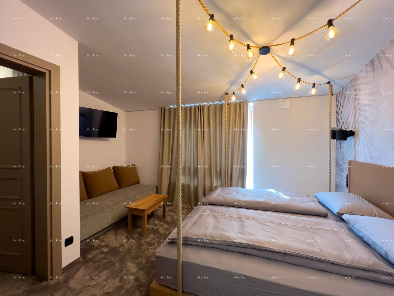 Weiterer Blick ins Schlafzimmer mit Bett, Sofa und dekorativer Lichterkette, die eine gemütliche Atmosphäre schafft.