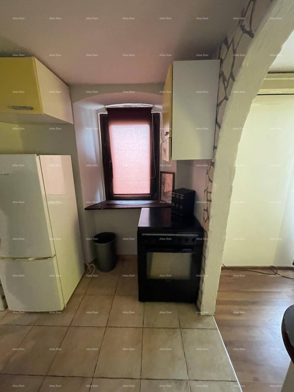 Küchenbereich mit Kühlschrank, Herd und einem Fenster, das natürliches Licht hereinlässt.