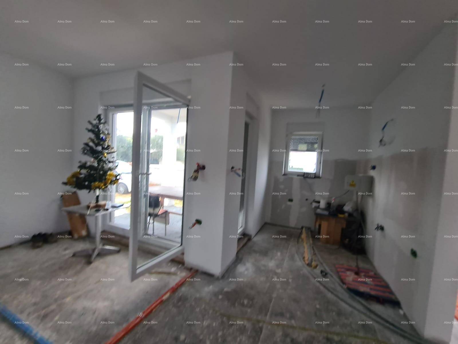 Rohbau-Innenraum mit großer Glastür, Fenster und sichtbaren Installationen, bereit für den Ausbau.