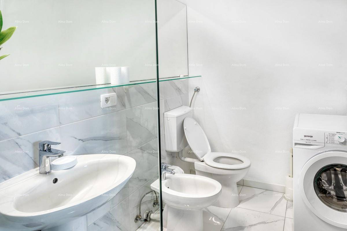 Geräumiges Badezimmer mit Dusche, Waschtisch, Toilette, Bidet und integrierter Waschmaschine.