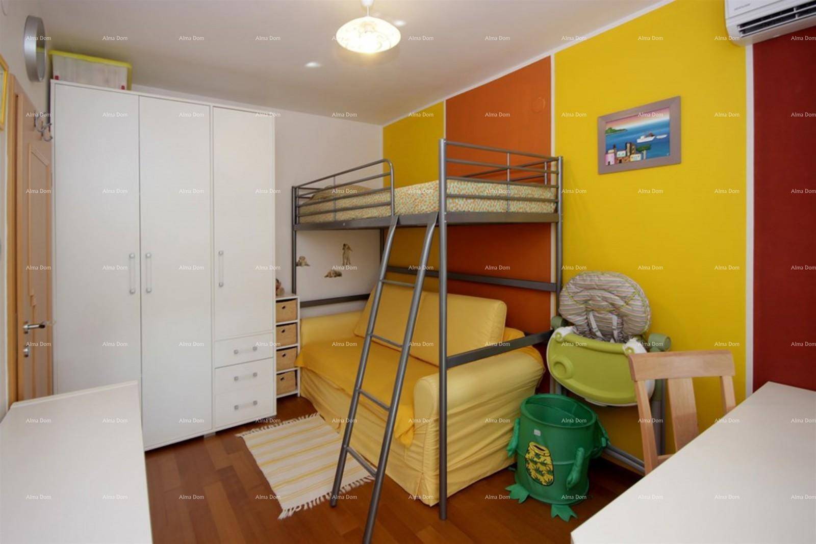 Buntes Kinderzimmer mit Etagenbett, Kleiderschrank und Schreibtisch.