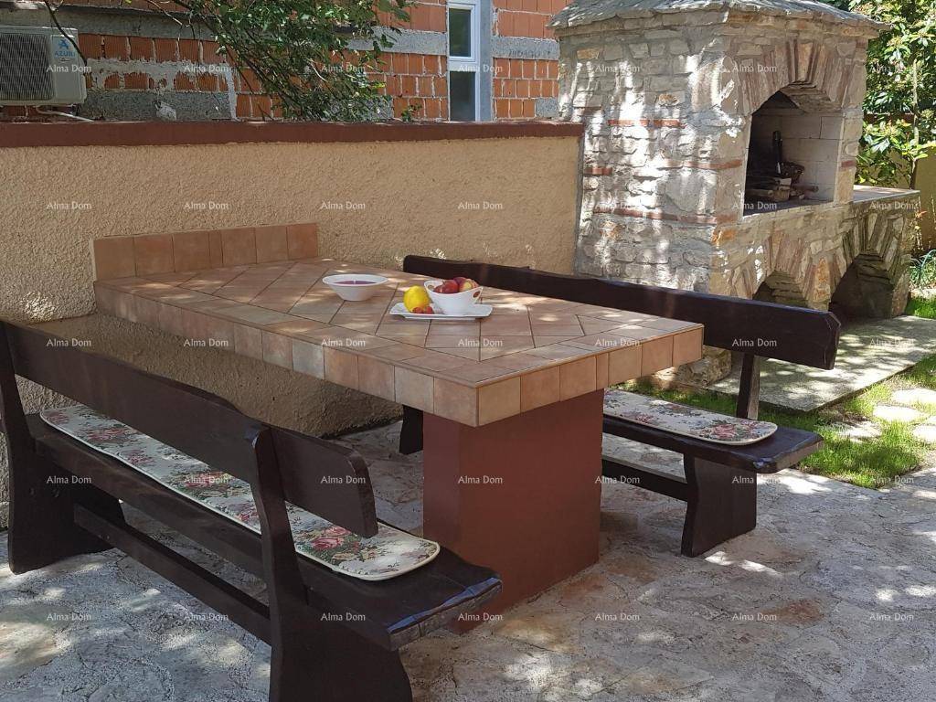 Gemütlicher Essbereich im Freien mit Steingrill und rustikalen Holzbänken für gesellige Stunden.