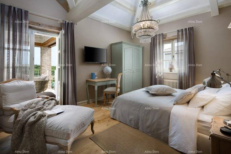 Geräumiges Schlafzimmer mit Kronleuchter, Schreibtisch und Zugang zum Balkon.