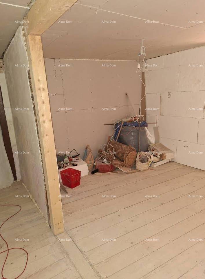 Unfertiger Innenraum mit Holzdielenboden und Baumaterialien, bereit für weitere Renovierungsarbeiten.