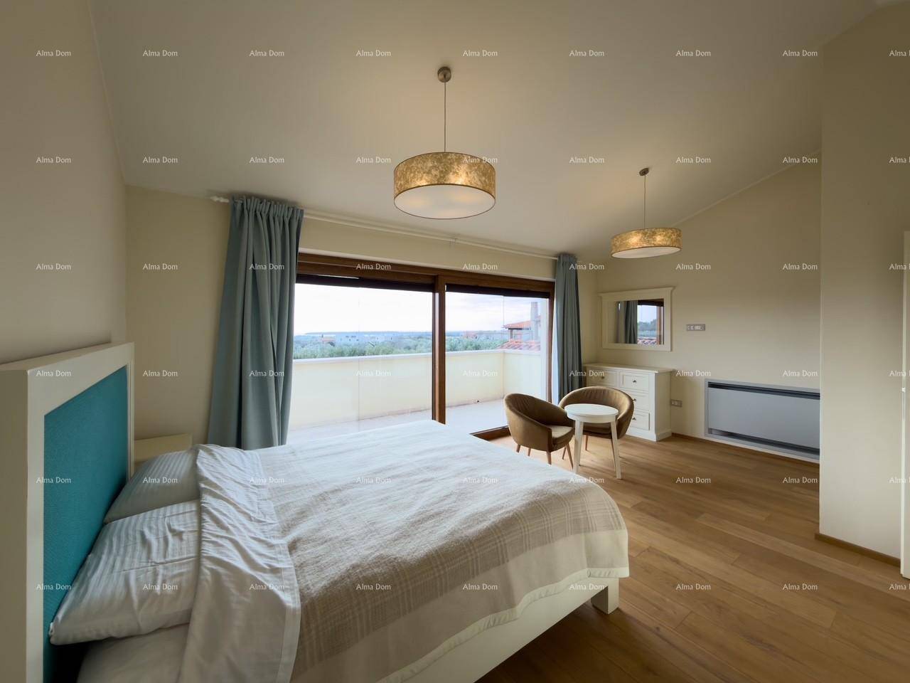 Helles Schlafzimmer mit Doppelbett, Sitzbereich und weitem Ausblick durch die großen Terrassentüren.