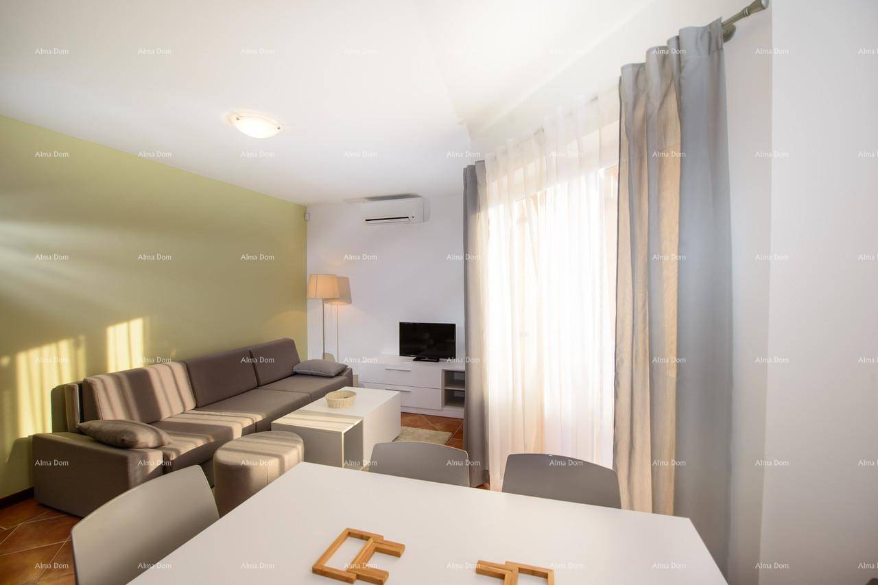Gemütlicher Wohn- und Essbereich mit beigem Sofa und großem Fenster.