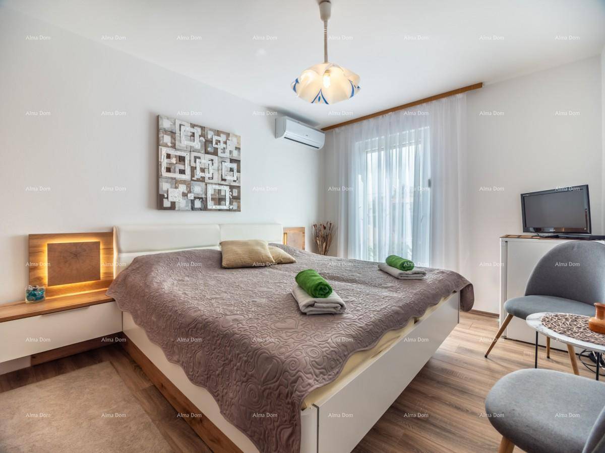 Schlafzimmer mit Doppelbett, Klimaanlage, Holzboden und Zugang zu einem sonnigen Balkon.