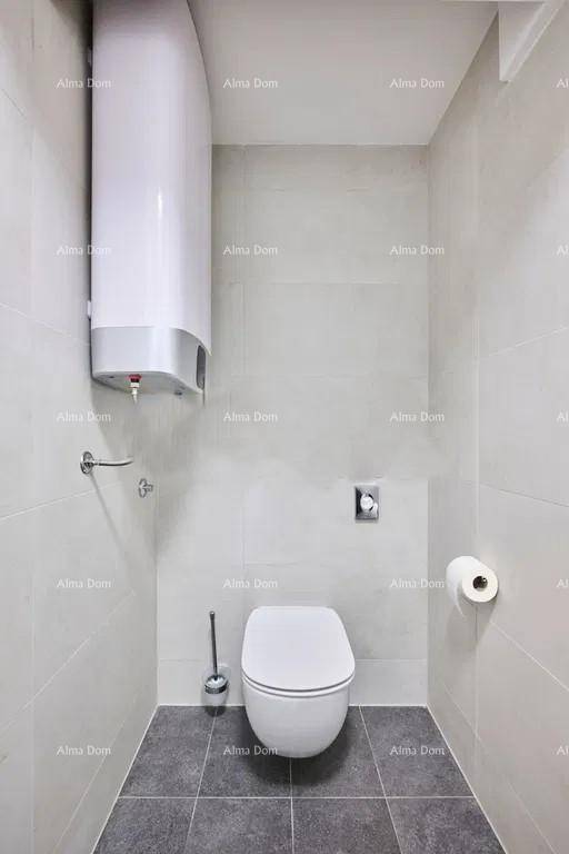 Modernes WC mit Wand-WC, Fliesen an Wänden und Boden sowie einem Warmwasserboiler.