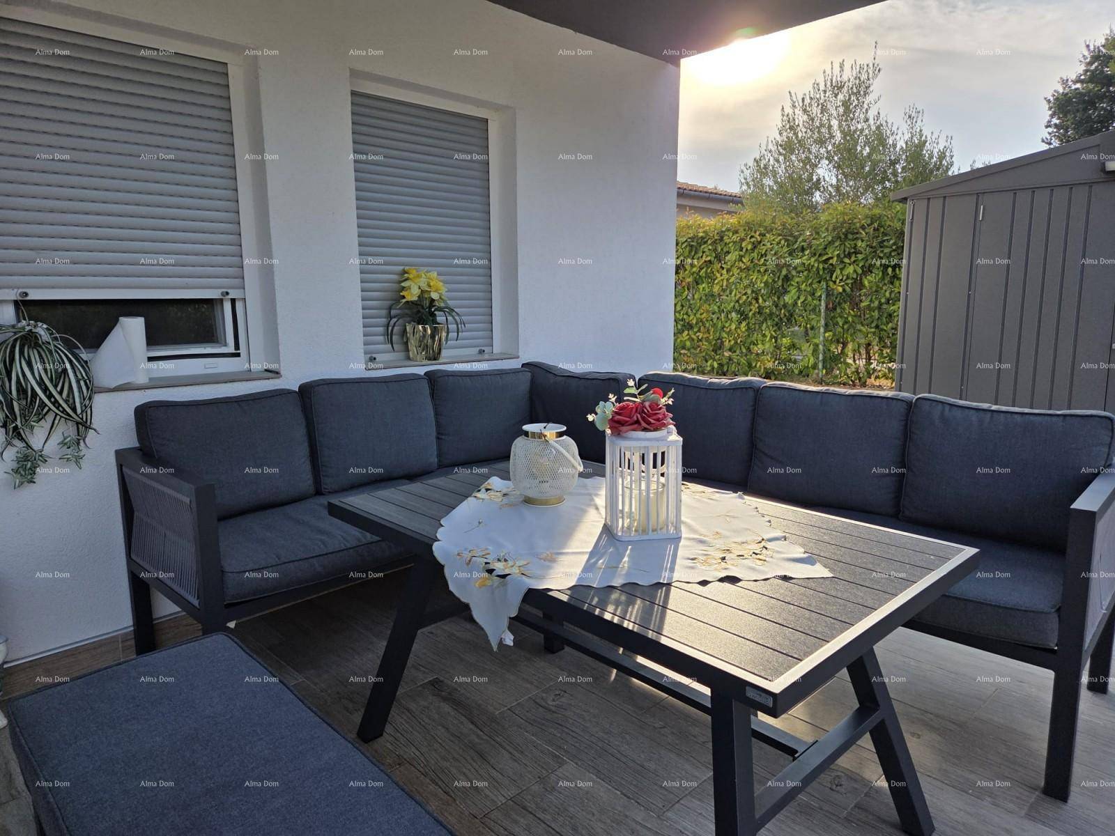 Sonnige Terrasse mit bequemen Loungemöbeln und einem gedeckten Tisch für Mahlzeiten im Freien.