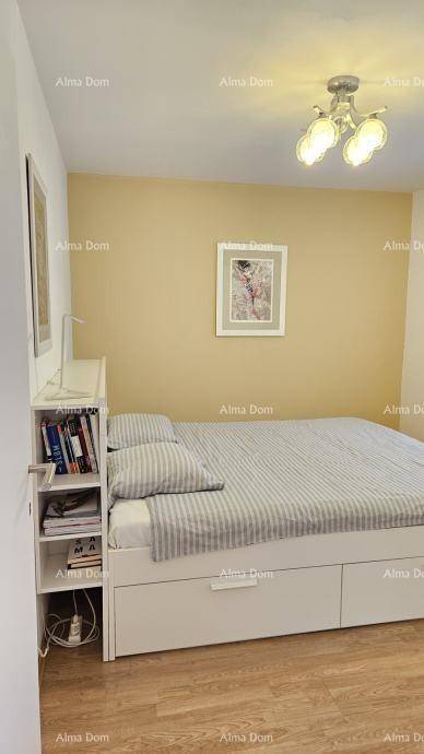 Gemütliches Schlafzimmer mit Holzboden, Bett und gelber Akzentwand.