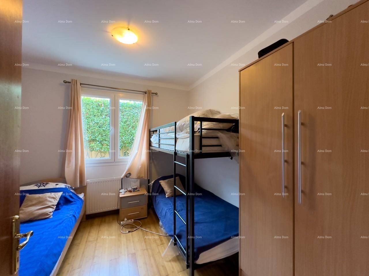 Kinderzimmer mit Einzelbett und Etagenbett, Holzboden und Fenster mit Blick ins Grüne, gemütlich.