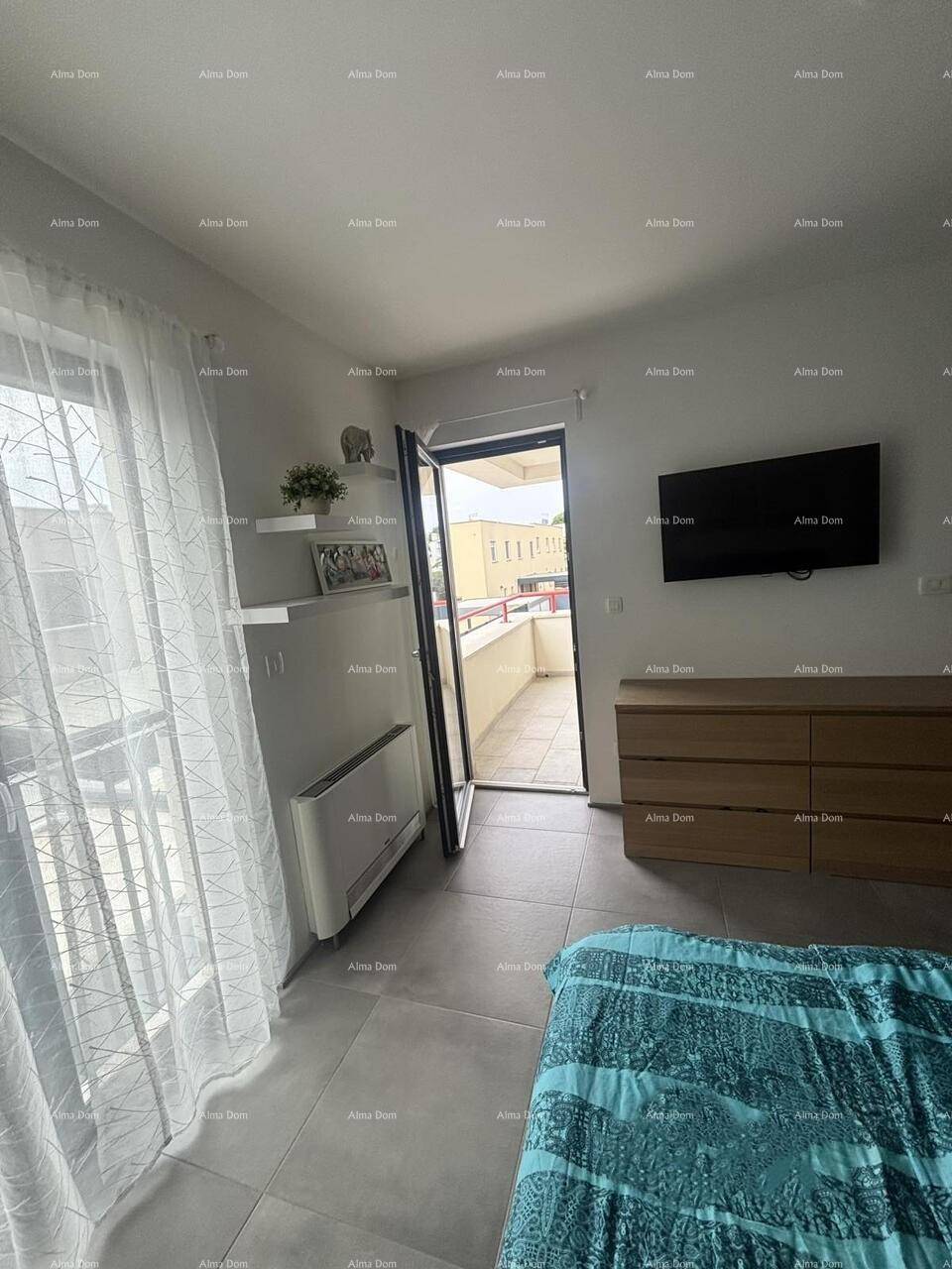 Schlafzimmer mit Zugang zu einem Balkon, Doppelbett und moderner Einrichtung.